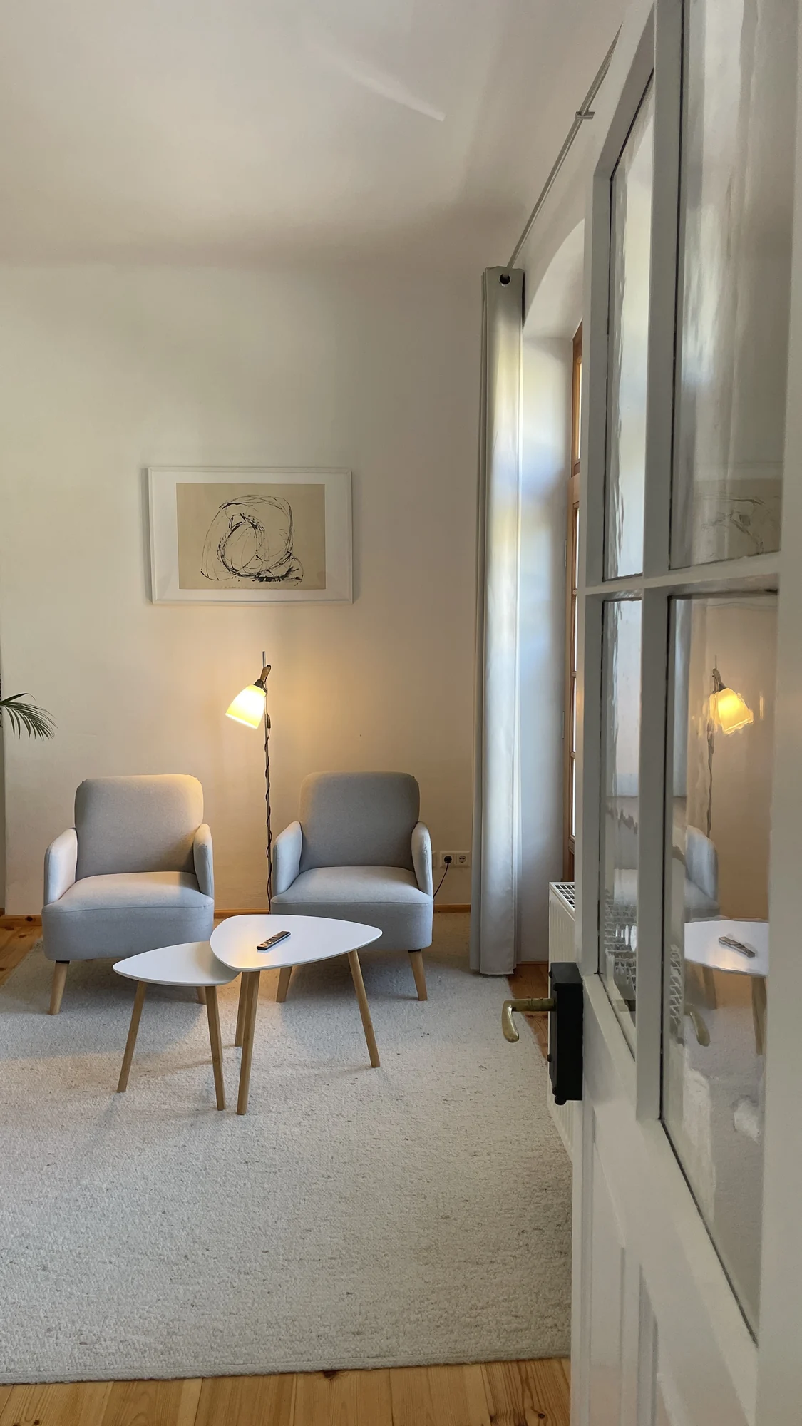 Wohnbereich am Abend mit Stehlampe und alter Glastür