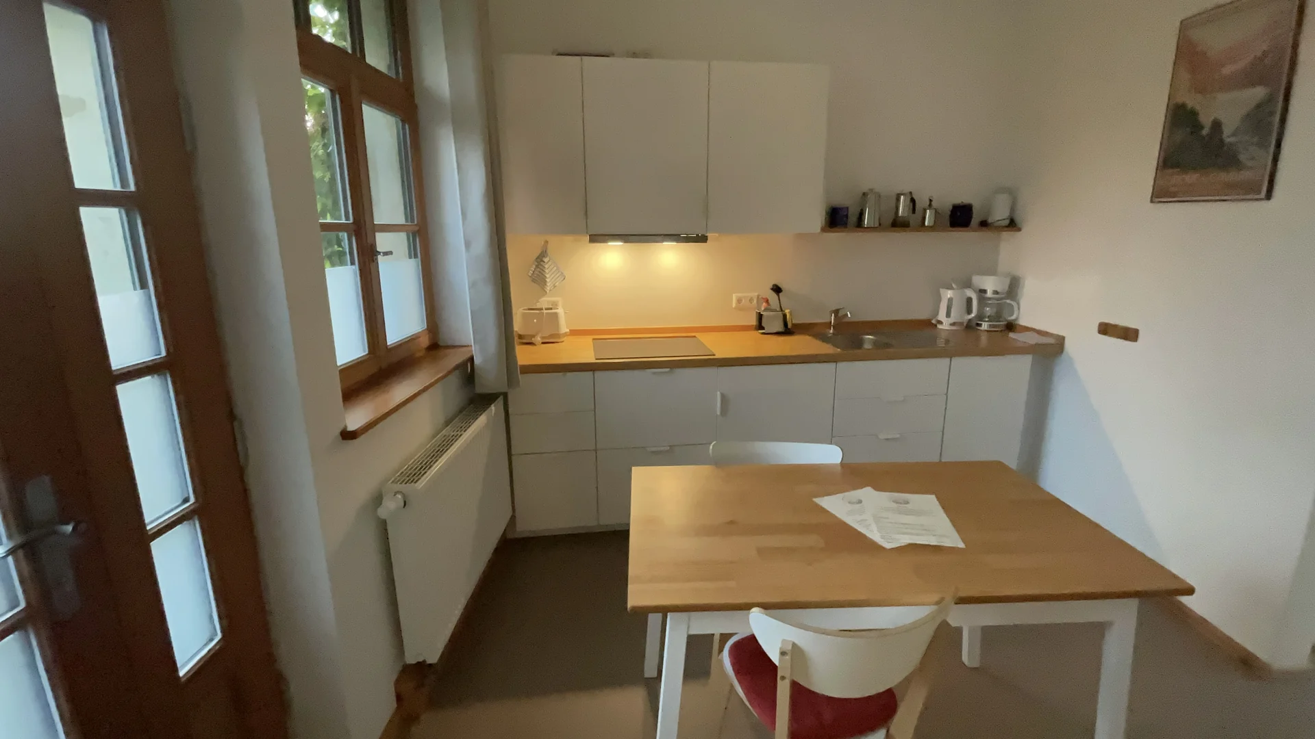 Küche mit Induktionskochfeld, Dunstabzugshaube, Espressomaschine und Esstisch